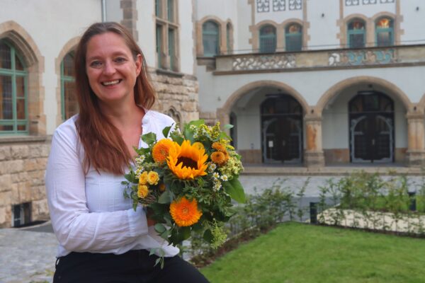 Kathleen Lützkendorf mit einem Blumenstrauß vor dem Volkshaus in Jena.